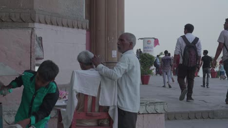 Indian-Man-Giving-A-Haircut-On-The-Side-Of-The-Road-At-A-Market-Stall