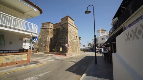 Approaching-the-Torre-Vigía,-the-old-Watch-Tower-in-the-sea-side-town-of-La-Cala-De-Mijas-on-the-Costa-Del-Sol-in-Southern-Spain