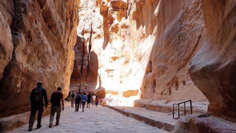 Tourists-walk-between-the-high-gorge-walls-on-the-way-to-the-ancient-city-of-Petra