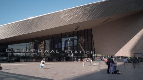 Timelapse-of-the-Central-Train-Station-in-Rotterdam,-Netherlands-on-a-sunny-day-with-many-people-walking