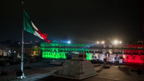 Zócalo-with-the-National-Palace,-Templo-Mayor,-and-a-waving-Mexican-flag-during-Mexico's-Independence-Day-and-el-Grito-de-Independencia