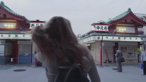 Chica-Turista-Rubia-Caminando-Hacia-El-Famoso-Templo-Sensō-ji-Asakusa-En-Tokio,-Japón,-En-Un-Día-Soleado-Y-Nublado