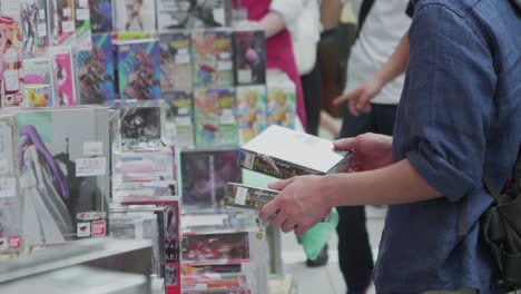 Man-Shopping-for-Fantasy-Video-Games-at-a-Street-Vendor-in-Tokyo,-Japan