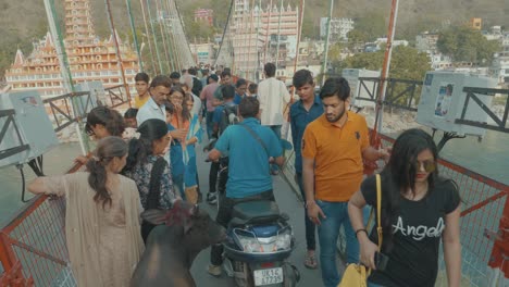 Belebte-Brücke-In-Indien-Mit-Fußgängern,-Fahrenden-Motorrädern-Und-überquerenden-Kühen