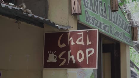 Schwenkt-Auf-Ein-Ladenschild-Auf-Einem-Gehweg,-Das-Für-Einen-Chai-Laden-In-Indien-Wirbt