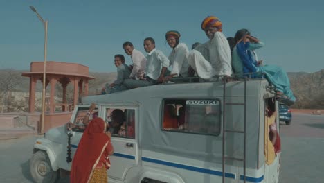 Viele-Menschen-Sitzen-Auf-Dem-Dach-Eines-Autos-Und-Verstoßen-Gegen-Alle-Verkehrssicherheitsgesetze-In-Indien,-Was-Zu-Vielen-Unfällen-Führt