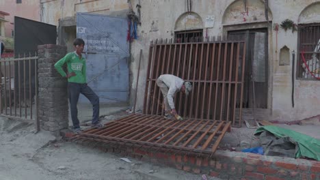 Männer-Arbeiten-In-Zeitlupe-Mit-Werkzeugen,-Um-Auf-Der-Straße-In-Indien-Einen-Eisenzaun-Zu-Bauen