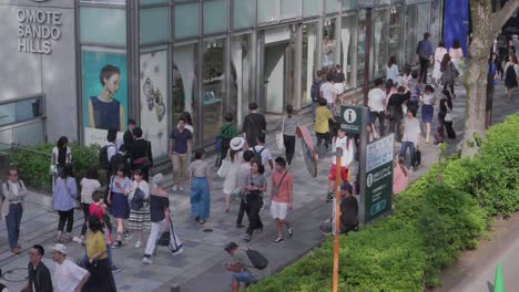 Handheld-pan-shot-of-people-crowd-on-sidewalk-and-Tokyo-city-traffic