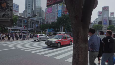 Muchos-Autos-Circulan-Por-El-Enorme-Cruce-De-Shibuya-En-Tokio,-Japón,-En-Un-Día-Soleado