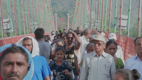 Crowds-Of-People-Walking-And-Motorbikes-On-A-Busy-Bridge-In-India-Green-And-Red-In-Color