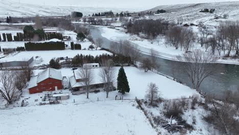 Drohnenaufnahme-Eines-Schneebedeckten-Ländlichen-Bauernhauses-Am-Rande-Des-Yakima-Flusses