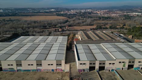 Aerial-overview-of-an-abandoned-industrial-garage-complex,-slide-left