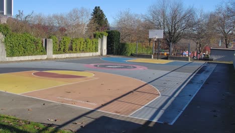 Leerer-Basketballplatz-In-Vancouver-An-Einem-Sonnigen-Tag,-Klare-Schatten-Von-Blattlosen-Bäumen,-Städtische-Umgebung
