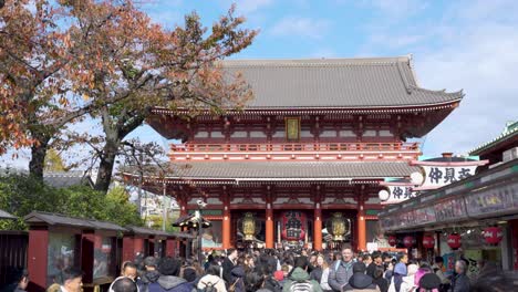Crowd-gathering-at-a-red-temple-Sensō-ji-in-Tokyo-under-clear-skies,-daytime
