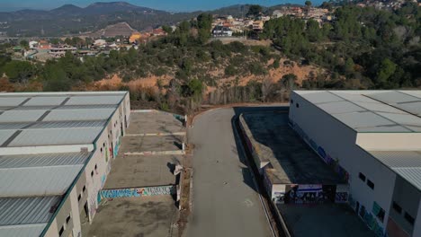 Aerial-reveal-shot-of-vandalized-abandoned-warehouse-complex-in-Spain