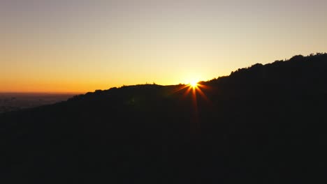 Sun-Peering-Through-Mountains-at-Runyon-Canyon,-Hollywood-Hills-Trail-as-Seen-By-Drone