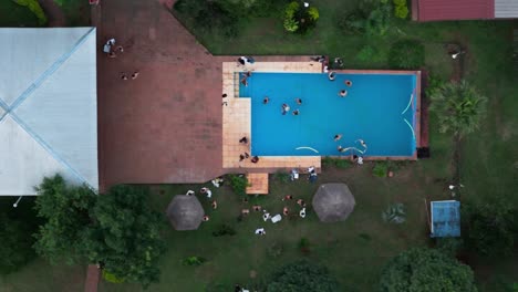 Top-down-drone-shot-over-the-property-with-Pool-with-people-enjoying-and-parting
