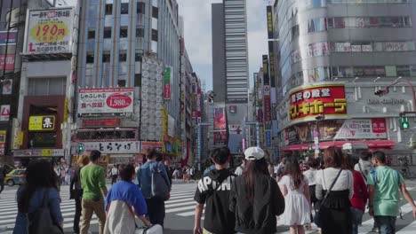Many-japanese-people-along-a-packed-road-in-Shinjuku,-Tokyo-before-covid19