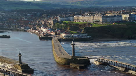 Establishing-Drone-Shot-of-Whitby-looking-down-River-and-Pier-High-Tide