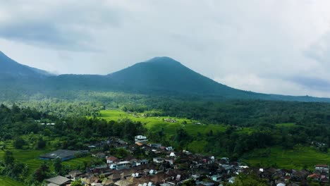 Experience-the-breathtaking-view-as-a-massive-mountain-stands-tall,-overlooking-a-charming-town-in-Bali,-Indonesia