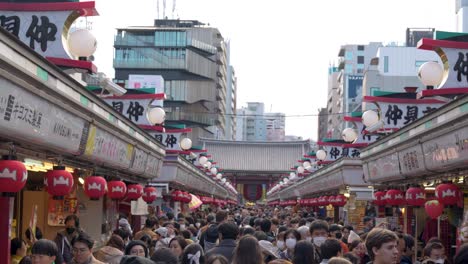 Bustling-Tokyo-market-Nakamise-dori-Street-with-red-lanterns,-crowd-shopping