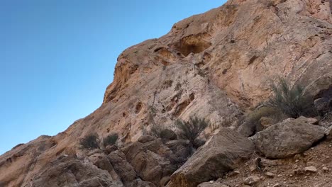 nomad-handmade-house-carved-in-rock-cliff-in-nature-the-historical-manmade-hole-in-rock-mountain-traditional-life-in-wild-natural-landscape-fig-fruit-tree-grow-in-Iran-blue-sky-rocky-panoramic-view