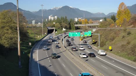 Busy-highway-with-cars-near-mountains-on-sunny-day,-Vancouver,-Canada,-aerial-view