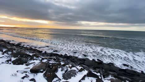 Langisandur-beach-at-sunset-with-waves-rinsing-black-volcanic-rocks