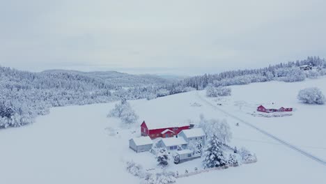 Vista-Aérea-Sobre-Cabañas-Cubiertas-De-Nieve-En-El-Campo-De-Noruega-Durante-El-Invierno---Disparo-De-Drones