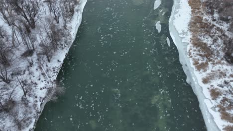 Drone-shot-of-the-Yakima-River-during-winter,-snow-covering-the-shoreline