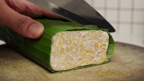 Closeup-of-tempeh,an-Indonesian-traditional-dish-of-fermented-soy-bean-being-cut