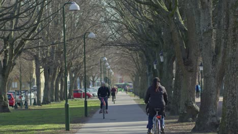 Vía-En-Un-Parque-Público-Arbolado-Con-Ciclistas-En-Malmo,-Suecia