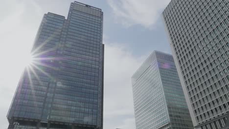 Un-Rascacielos-Muy-Moderno-En-Tokio,-Japón,-Con-El-Sol-Reflejándose-En-él.