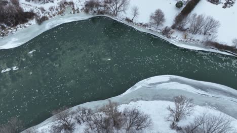Rising-overhead-drone-shot-of-ice-floating-down-the-Yakima-River-in-Washington