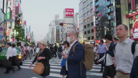 Viele-Japaner-überqueren-Während-Der-Hauptverkehrszeit-Eine-überfüllte-Straße-In-Shinjuku,-Tokio