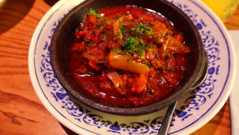 Delicious-spicy-Chakhokhbili-Georgian-chicken-stew-with-tomatoes-and-herbs-at-a-restaurant,-traditional-cuisine,-4K-shot