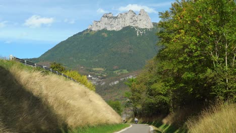 Los-Ciclistas-Viajan-Por-El-Carril-Bici-Cerca-Del-Lago-De-Annecy-Con-La-Majestuosa-Montaña-Al-Fondo.