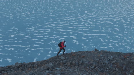 Gefrorener-Gletschersee-Am-Höchsten-Gipfel-Der-Welt,-Mount-Everest-Region,-Nepal,-Männer-Erklimmen-Hügel-Mit-Stockunterstützung,-Genießen-Die-Aussicht-In-Ehrfurcht.-Drohnenaufnahme-Enthüllt-Filmische-Landschaftsansicht,-4k