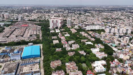 Profile-drone-view-of-residential-buildings-with-trees-surrounding-them-in-Chennai,-India-during-daytime