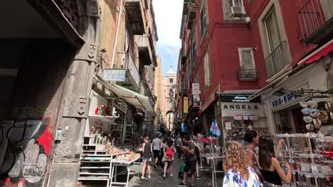 POV-shot-of-walking-a-narrow-street-with-football-symbolic-in-the-city-center-of-Naples-in-Italy