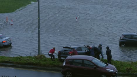 Residents-come-together:-Pushing-car-out-of-flooded-parking-during-storm