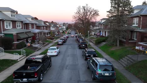 Twilight-over-a-quiet-residential-street-lined-with-brick-houses-and-parked-cars