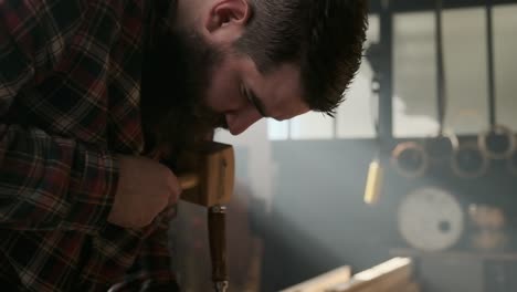 Carpenter-working-with-pouch-in-moody-workshop