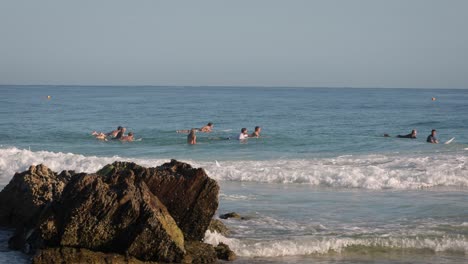 Surfers-waiting-for-waves-on-a-calm-sunny-day-at-Snapper-Rocks,-Gold-Coast