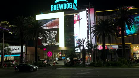 Tilt-Up-View-From-Across-Las-Vegas-Strip-To-Reveal-Illuminated-BrewDog-Sign-On-Top-Of-Building-At-Night