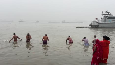 Rückansicht-Einiger-Alter-Männer,-Die-Am-Babu-Ghat-In-Kalkutta-Baden,-Mit-Nebliger-Meereslandschaft-Im-Hintergrund-In-Indien