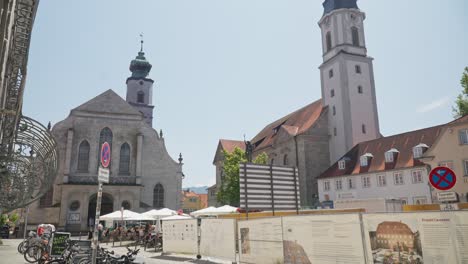 Sunny-day-in-Lindau-with-view-of-historic-church-and-bustling-outdoor-cafe,-clear-sky