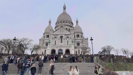 Crowded-steps-leading-up-to-the-Basilica-of-Sacré-Cœur-in-Montmartre,-Paris,-with-visitors-milling-about