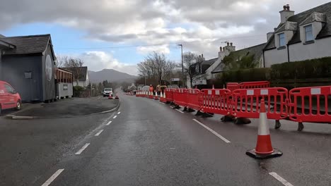Overcast-day-showing-roadworks-on-a-suburban-street-in-Skye,-Scotland-with-safety-barriers-and-cones