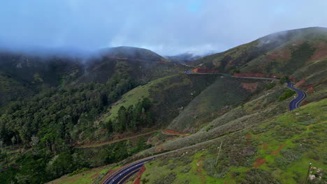 Wunderschöne-Luftaufnahme-Eines-Rennens-Am-Rande-Der-Berge,-Umgeben-Von-Natur,-Bäumen-Und-Niedrigen-Wolken-Vom-Aussichtspunkt-Golden-Gate